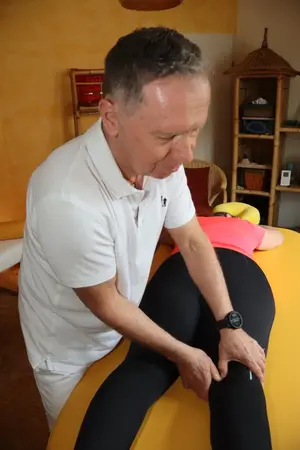 Ein Physiotherapeut behandelt eine Patientin bei einer professionellen Massage im Behandlungsraum.